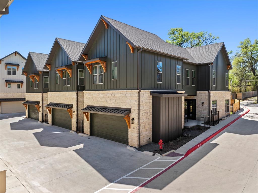 3500 Pecan Springs Road, Unit 9 Austin, TX 78723 - Photo 5 of 9 View of home's exterior with board and batten siding, roof with shingles, stone siding, and a garage