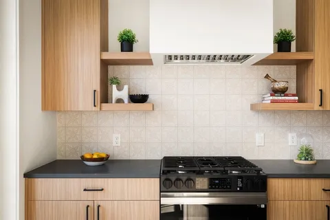 a kitchen with granite countertop a stove and a white cabinets