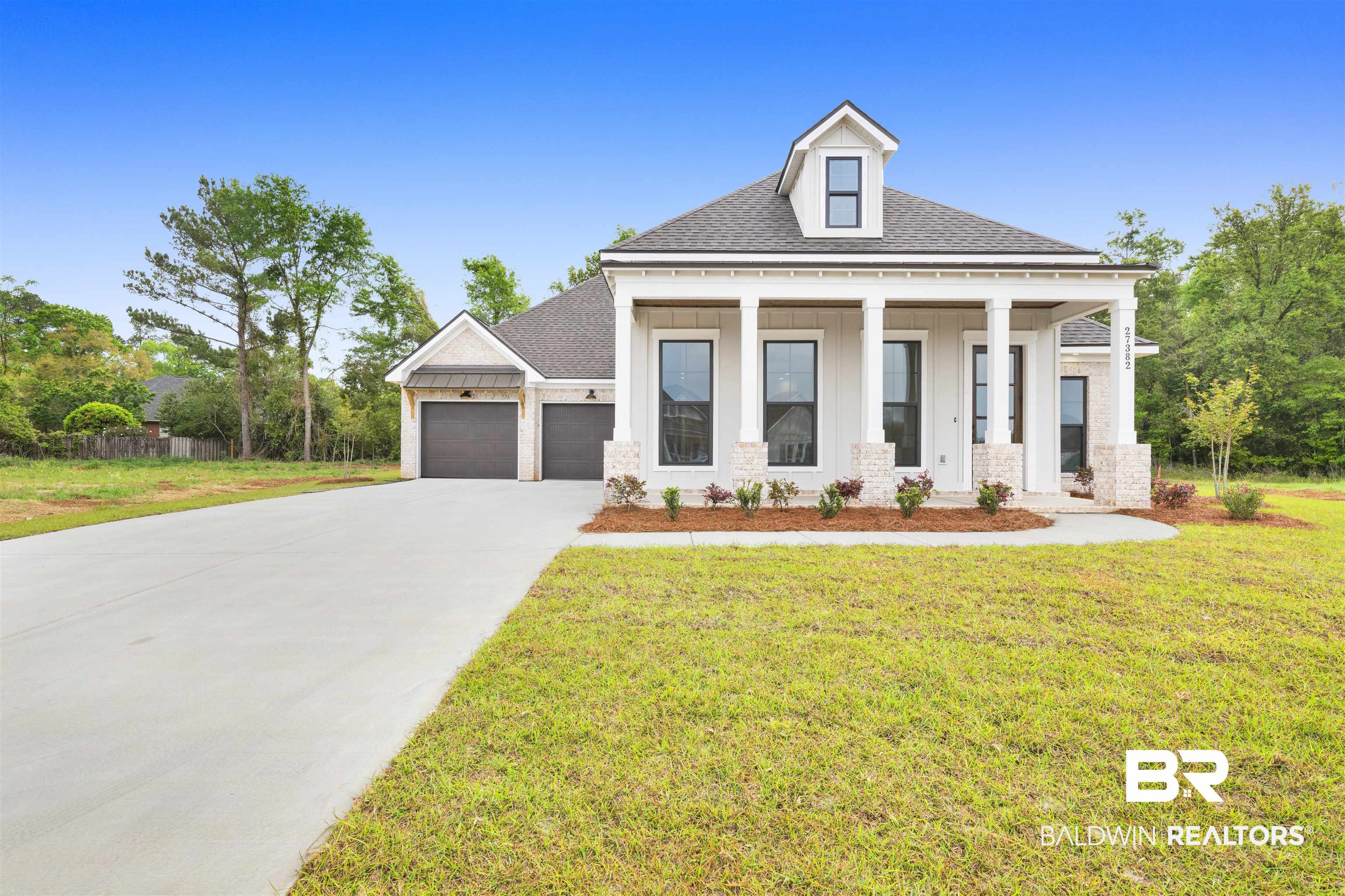 27382 Patch Pl Loop Daphne, AL 36526 - Photo 3 of 31 View of front facade featuring a front yard, a shingled roof, covered porch, board and batten siding, and concrete driveway