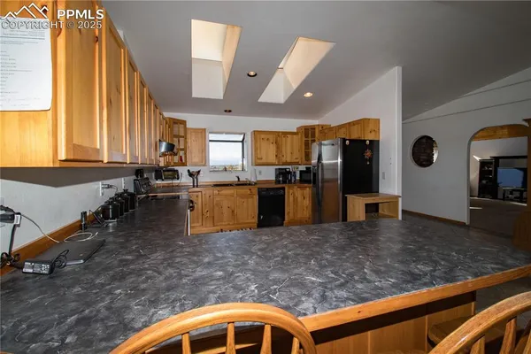 a kitchen with stainless steel appliances granite countertop a sink a stove counter space and windows