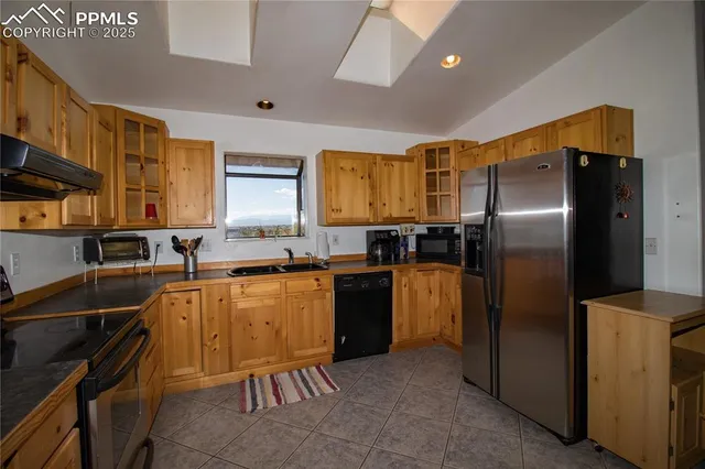 a kitchen with stainless steel appliances granite countertop a refrigerator a stove and a sink