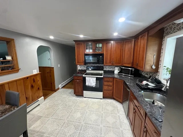 a kitchen with stainless steel appliances granite countertop a stove a sink and a refrigerator