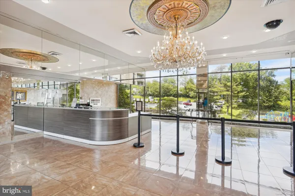 a room with lots of white furniture and chandelier