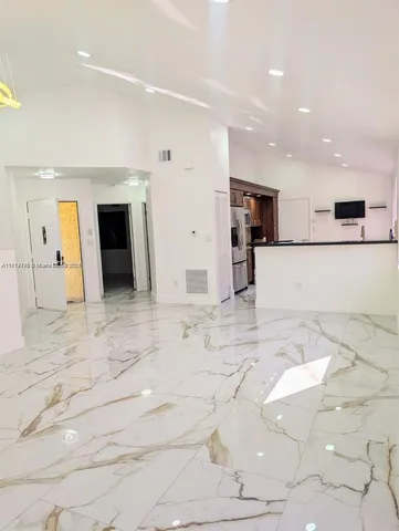 a large white kitchen with cabinets
