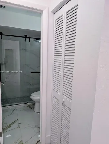 a bathroom with a toilet and a shower