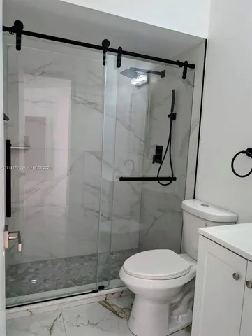 a bathroom with a toilet and a shower