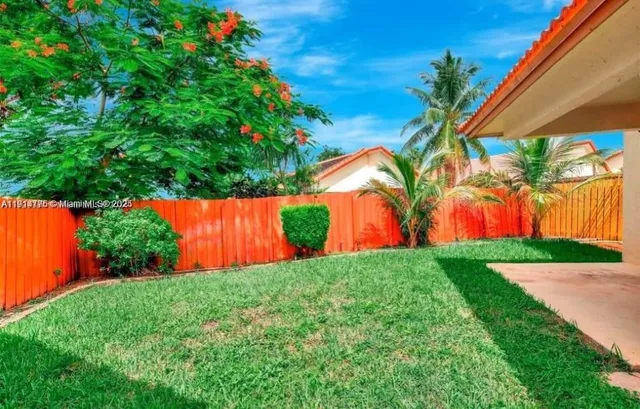a view of backyard with swimming pool and trees