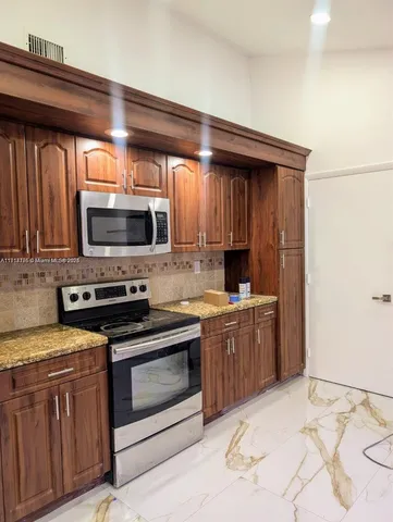 a kitchen with stainless steel appliances granite countertop a stove microwave and sink