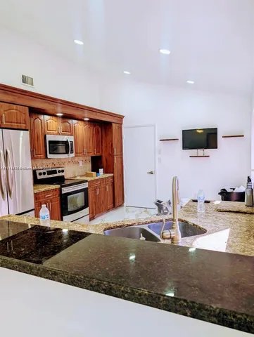 a kitchen with stainless steel appliances granite countertop a sink stove and refrigerator