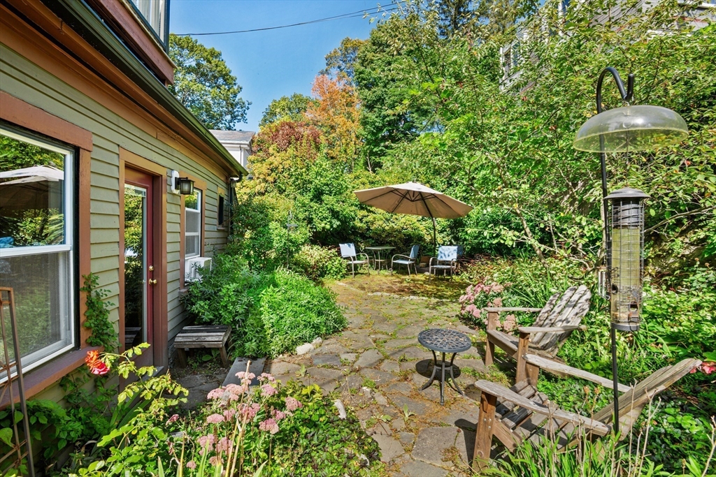 36 Alveston Street Boston, MA 02130 - Photo 16 of 38 a view of a patio with table and chairs under an umbrella