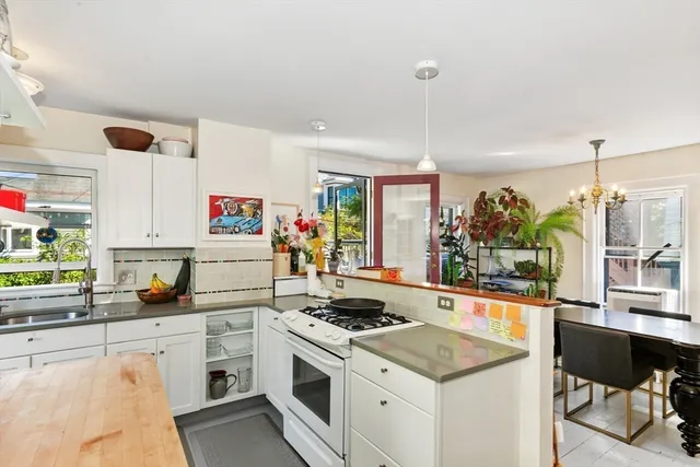 a kitchen with a sink a stove and white cabinets