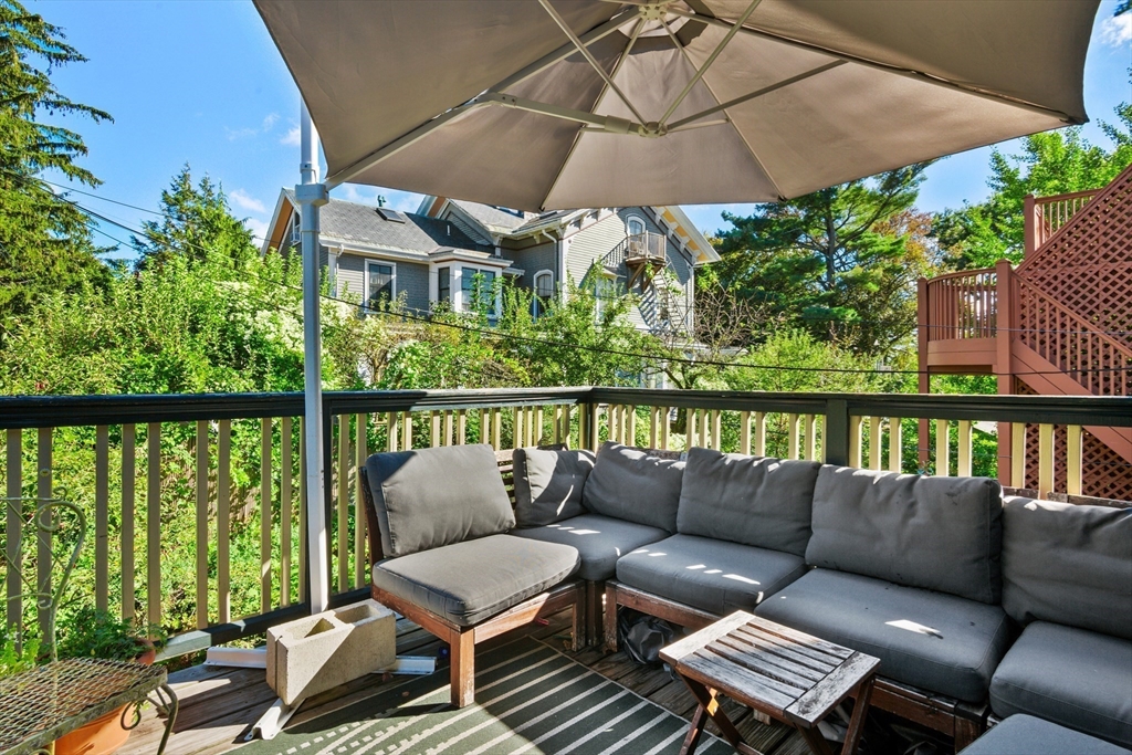 36 Alveston Street Boston, MA 02130 - Photo 23 of 38 a roof deck with a table and chairs under an umbrella