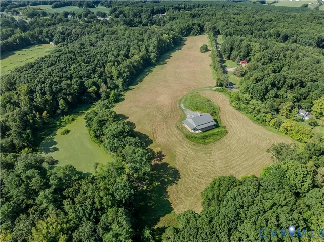an aerial view of a house with a yard and lake view