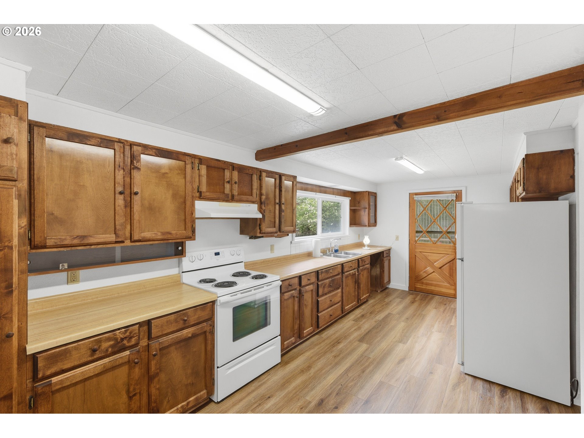 63299 Wildahl Road Coos Bay, OR 97420 - Photo 23 of 45 a kitchen with a stove a sink and a refrigerator