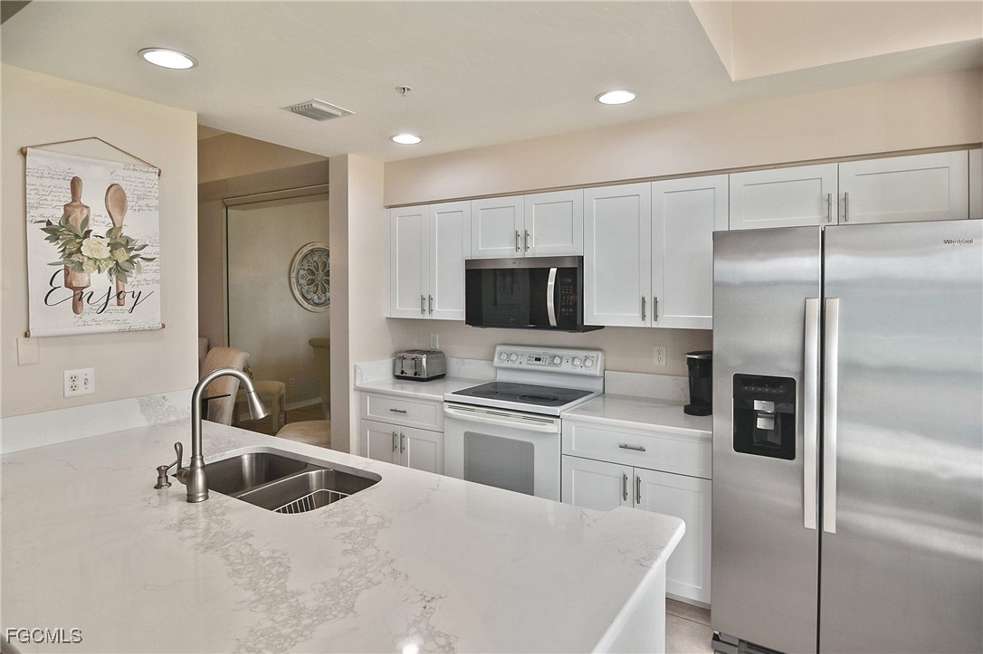 a kitchen with white cabinets and stainless steel appliances