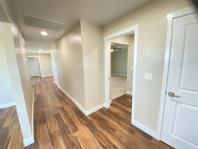 a view of a hallway with wooden floor