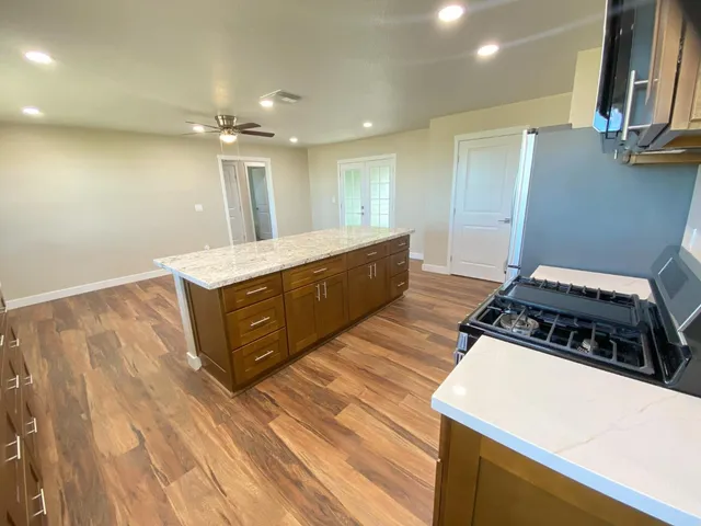 a kitchen with granite countertop a sink stove and cabinets
