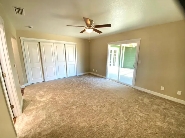 a view of a livingroom with a ceiling fan and window