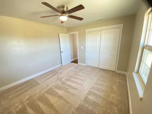 a view of a livingroom with a ceiling fan and window
