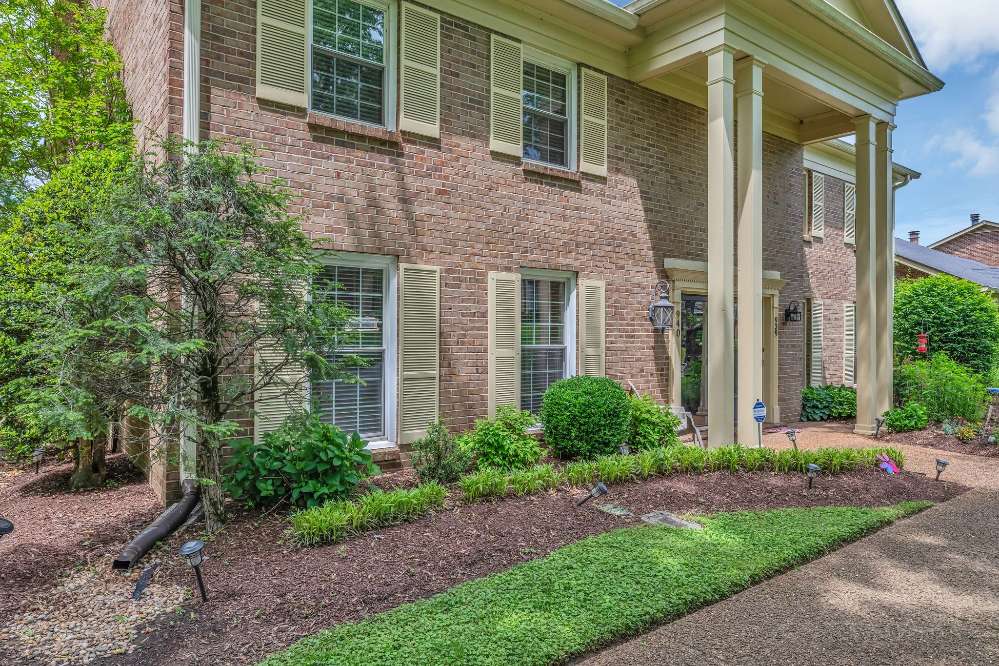 940 General George Patton Road Nashville, TN 37221 - Photo 3 of 35 a view of a brick house with a yard potted plants and a table