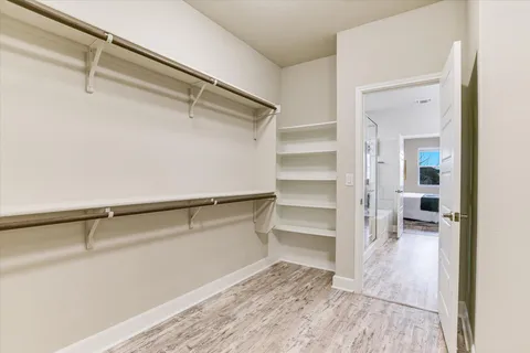 a view of walk in closet with empty racks