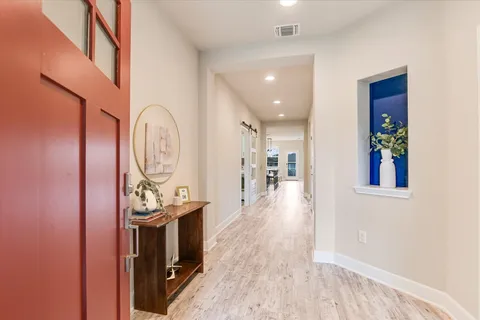 a view of a hallway with wooden floor and entryway