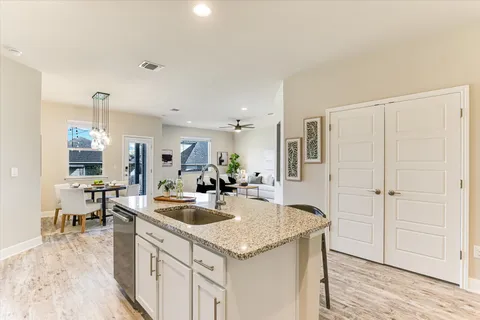 a kitchen with granite countertop a sink a counter top space and living room area