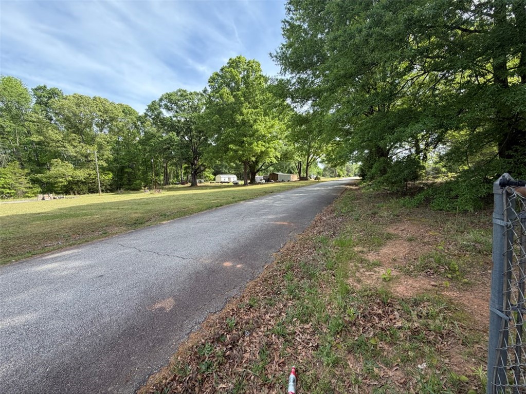 102 Sioux Street Laurens, SC 29360 - Photo 5 of 8 An inviting paved road winds through a lush, green landscape, offering serene views.