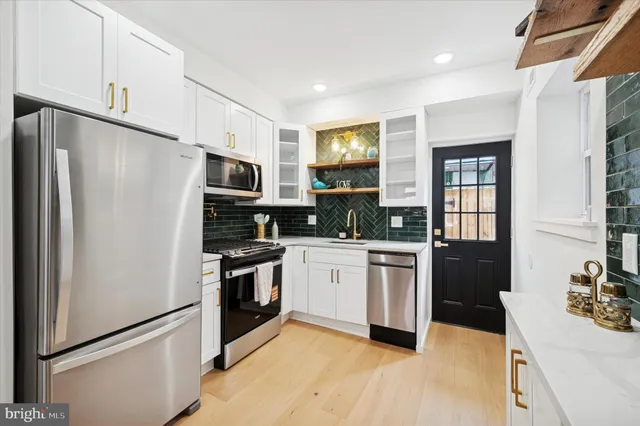 a kitchen with granite countertop a refrigerator stove top oven and sink