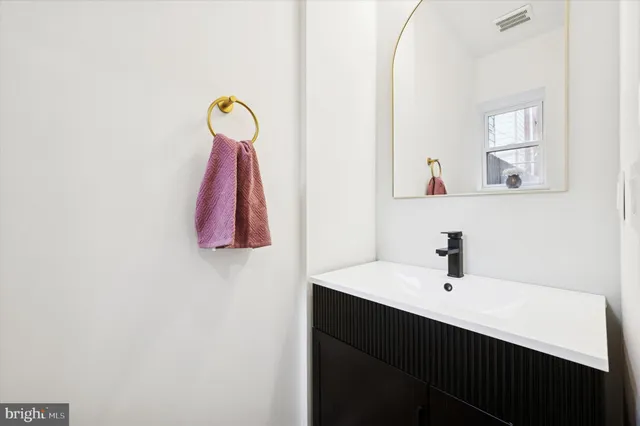 a view of a hallway with workspace and bathroom with mirror