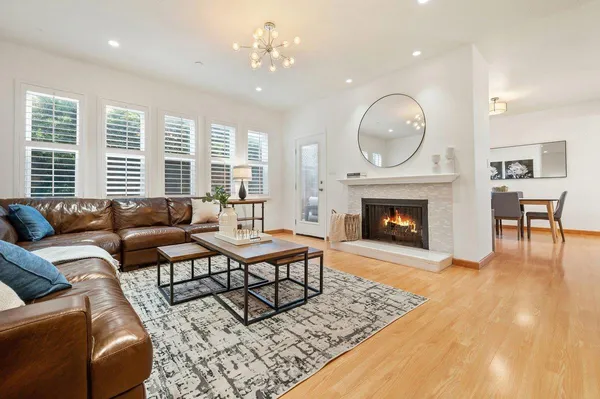 a living room with furniture a large window and a fireplace