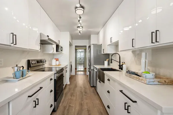 a kitchen with stainless steel appliances a sink stove and cabinets