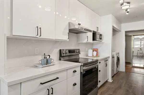 a kitchen with stainless steel appliances white cabinets and a sink