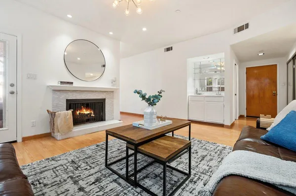 a living room with furniture a fireplace a rug and a window