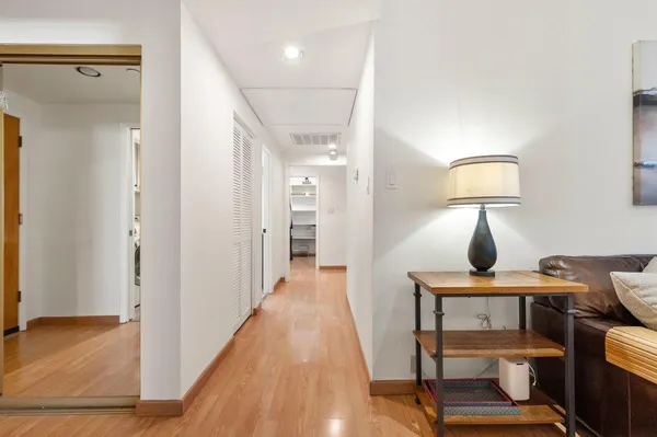 a view of a hallway with furniture and wooden floor