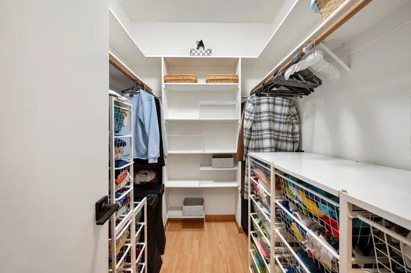 a view of walk in closet with clothes and shoes