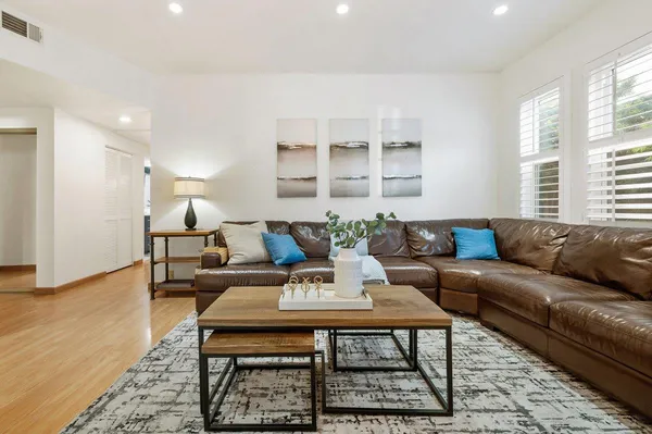 a living room with furniture wooden floor and a rug