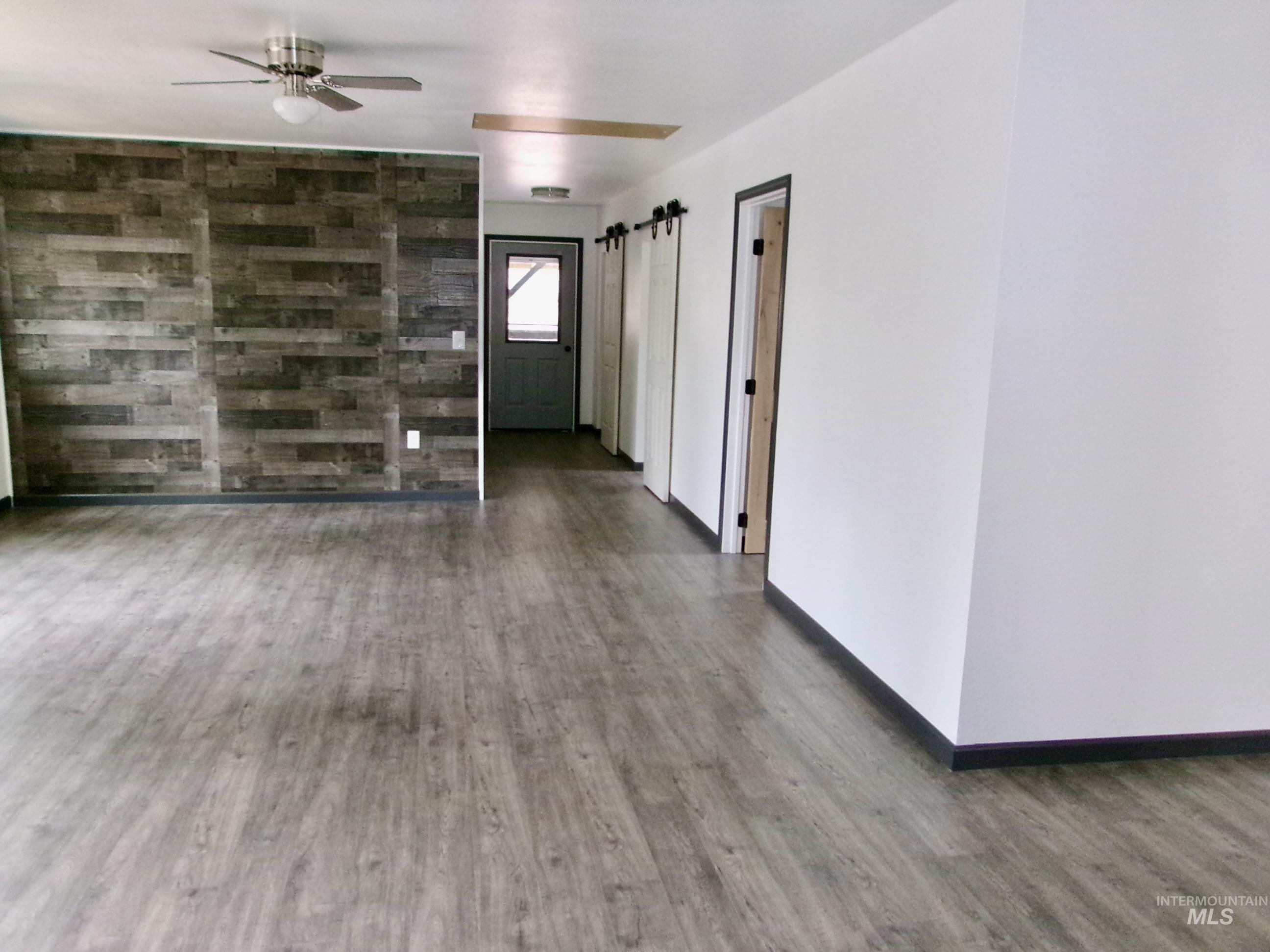 123 Conifer Lane Stites, ID 83552 - Photo 19 of 48 Spare room featuring wood finished floors, ceiling fan, and a barn door