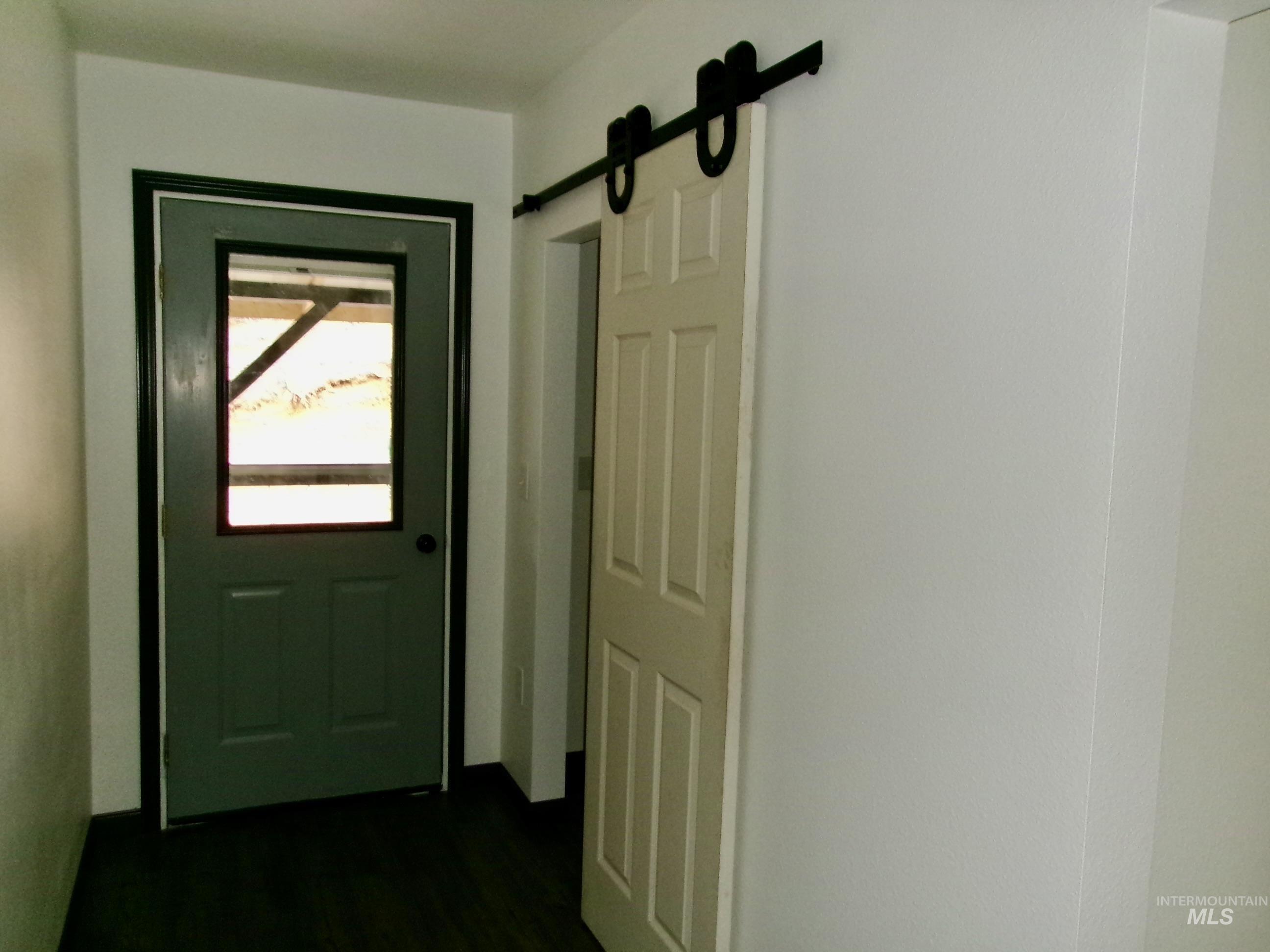 123 Conifer Lane Stites, ID 83552 - Photo 22 of 48 Doorway to outside featuring a barn door and wood finished floors