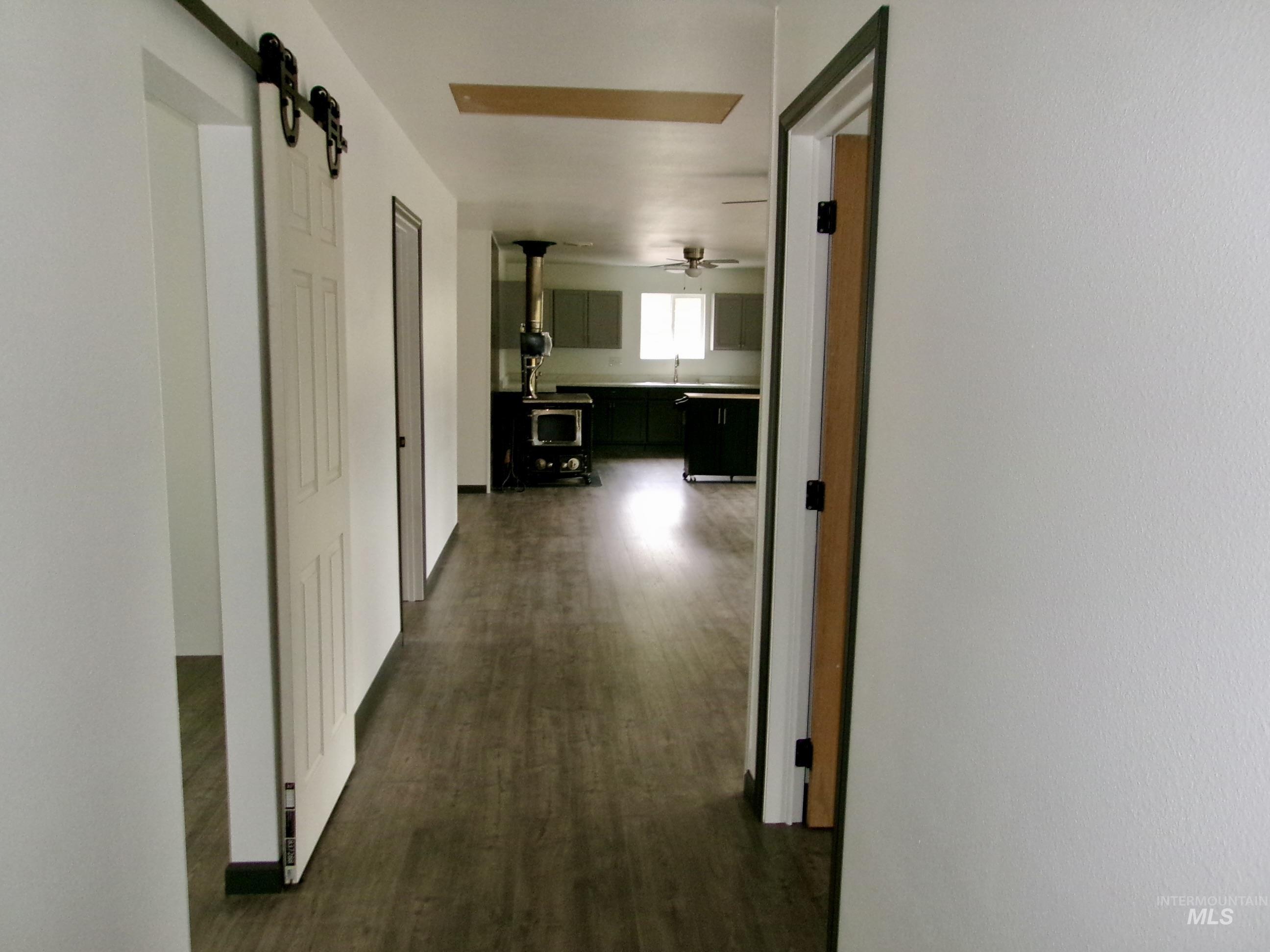 123 Conifer Lane Stites, ID 83552 - Photo 24 of 48 Hallway featuring a barn door and dark wood finished floors