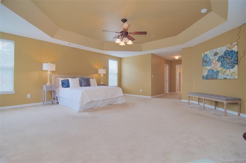221 Choate Avenue Fort Mill, SC 29708 - Photo 16 of 24 a spacious bedroom with a large bed and a chandelier