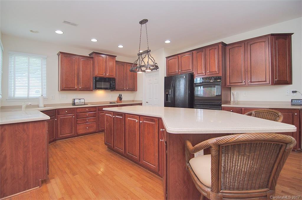 221 Choate Avenue Fort Mill, SC 29708 - Photo 7 of 24 a kitchen with kitchen island granite countertop a stove top oven a sink dishwasher and a cabinets with wooden floor