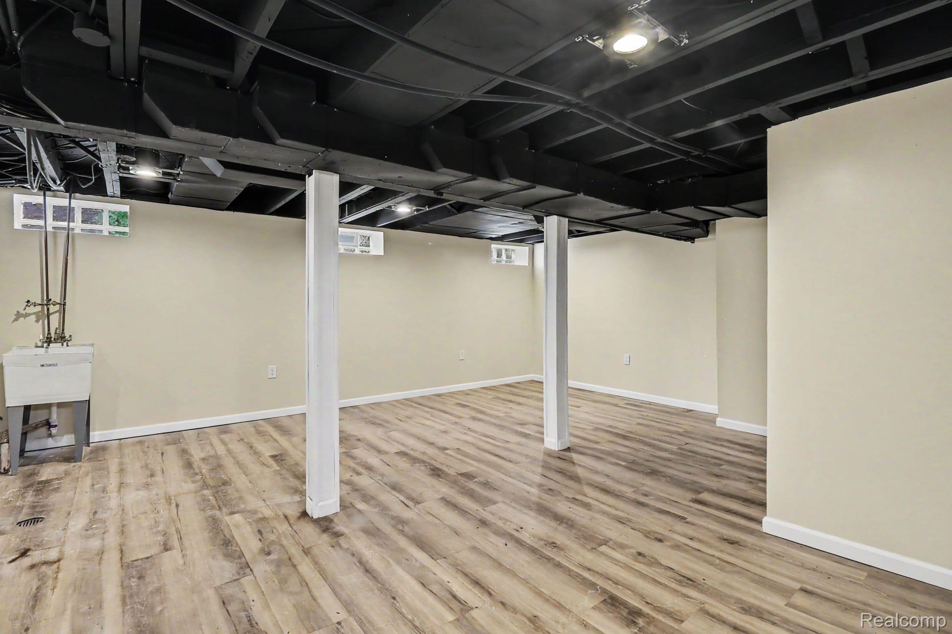 16682 Robson Street Detroit, MI 48235 - Photo 18 of 19 Spacious lower level featuring wood-finish flooring, painted walls, exposed painted ceiling joists, and recessed lighting