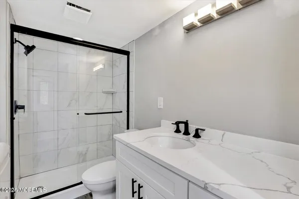 a bathroom with a sink a toilet and shower