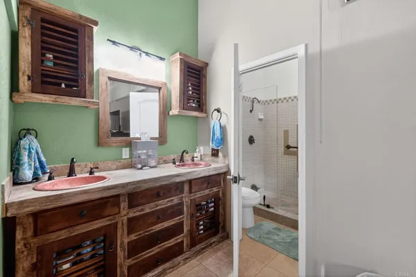 a bathroom with a double vanity sink mirror and shower