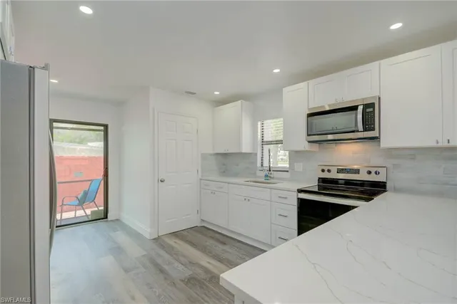 a kitchen with a refrigerator and a stove top oven