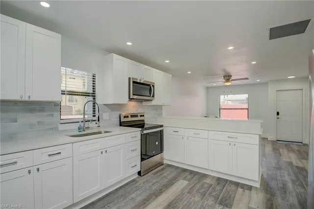 a kitchen with stainless steel appliances a stove sink and microwave