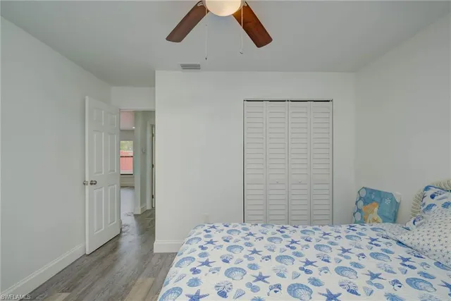 a bedroom with a bed and a lamp on the dresser