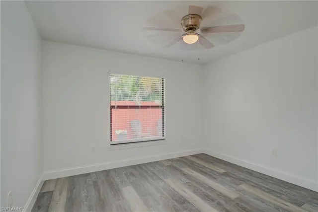 an empty room with a window and a ceiling fan