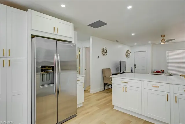 a kitchen with white cabinets a sink and appliances